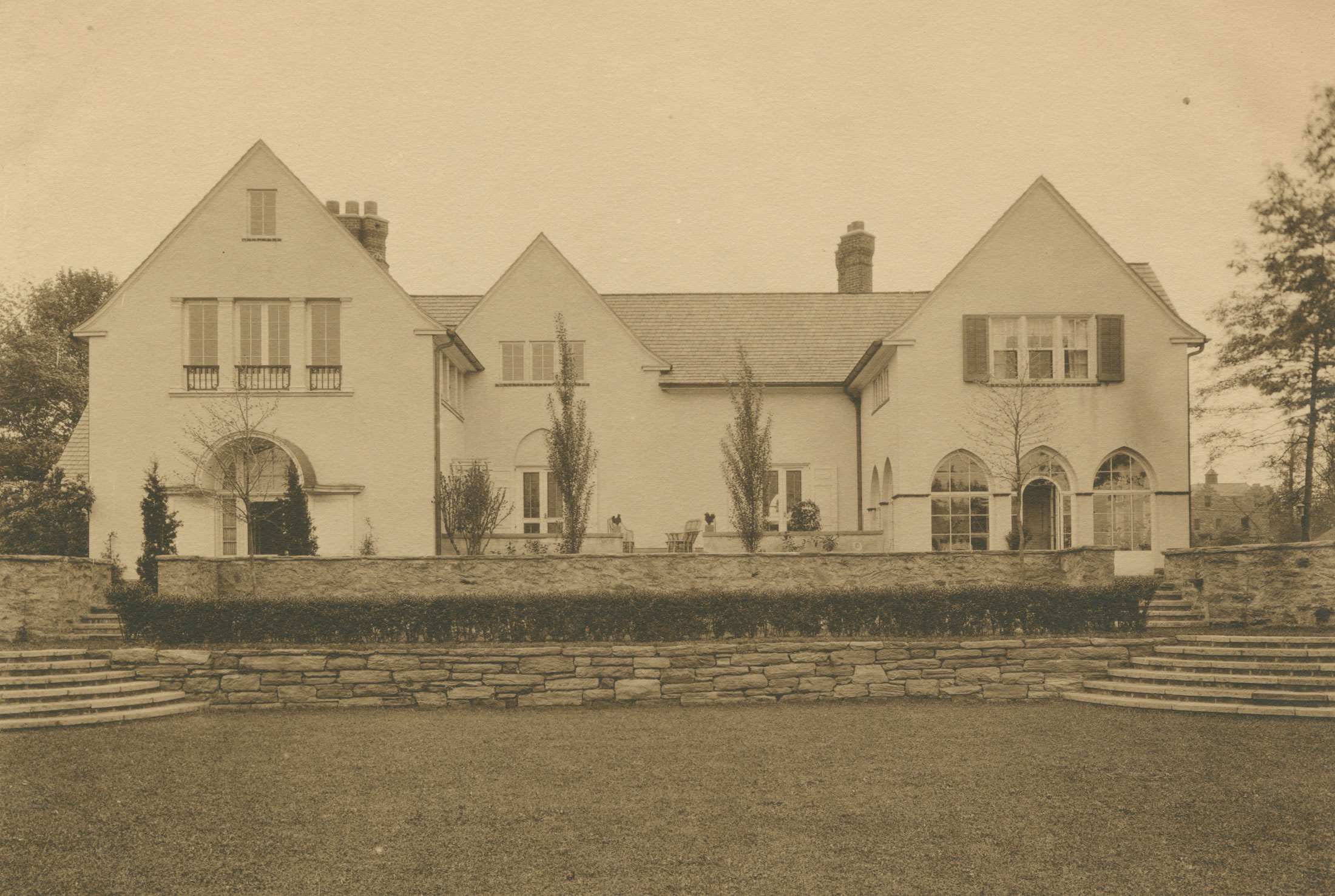 Black and white photograph of large house and garden