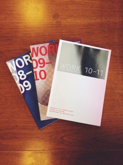 Three editions of the publication "Work" on a wooden table. The editions are "10-11", "09-10" and "08-09"