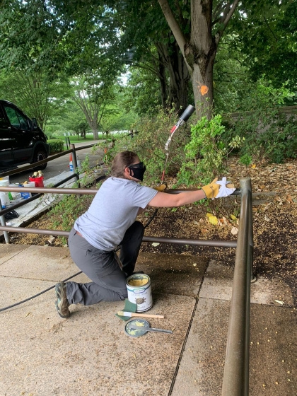 Jennifer Boggs applies hot wax to the bronze railings at Arlington National Cemetery.