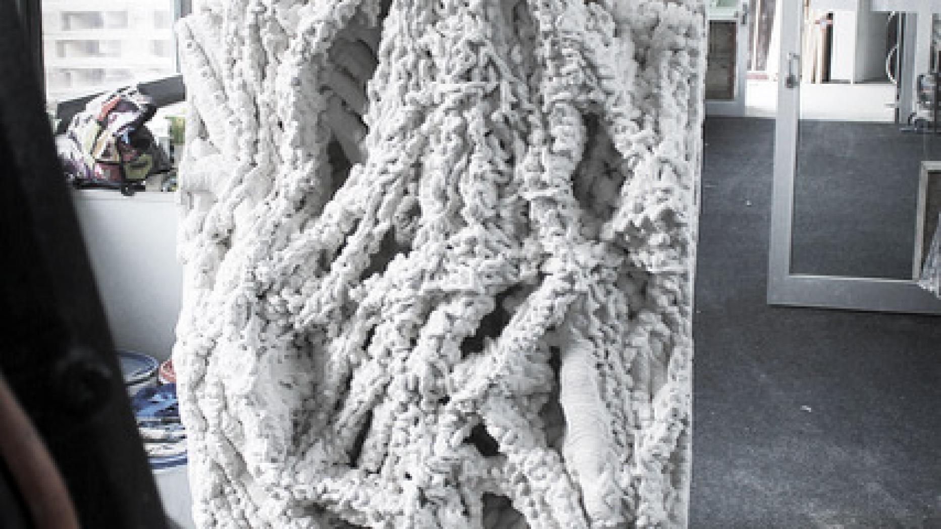 All white semi-organic looking sculpture that resembles a stalagmite or buildup of wet sand