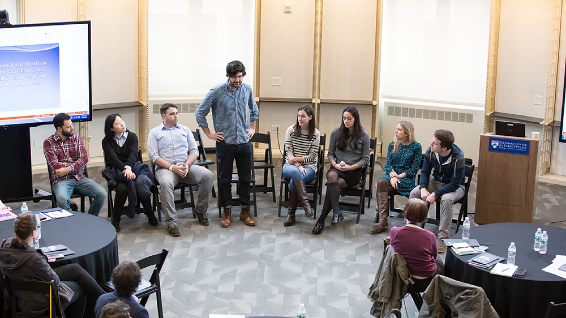 Students in a panel discussion, one standing