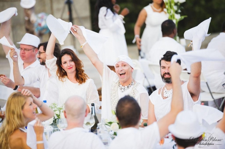 Guests raising towels and cheering at the Diner En Blanc