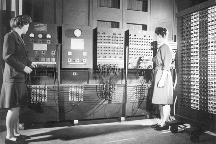 Black and white image of the ENIAC and two women "computers"