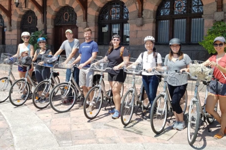 Group posing with bikes outside building in Mexico
