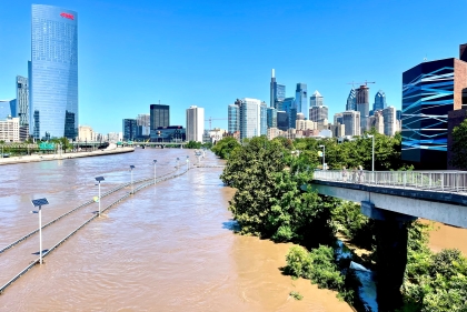 Schuylkill River crested above flood levels covering the River Walk with Philadelphia Skyline in the background.
