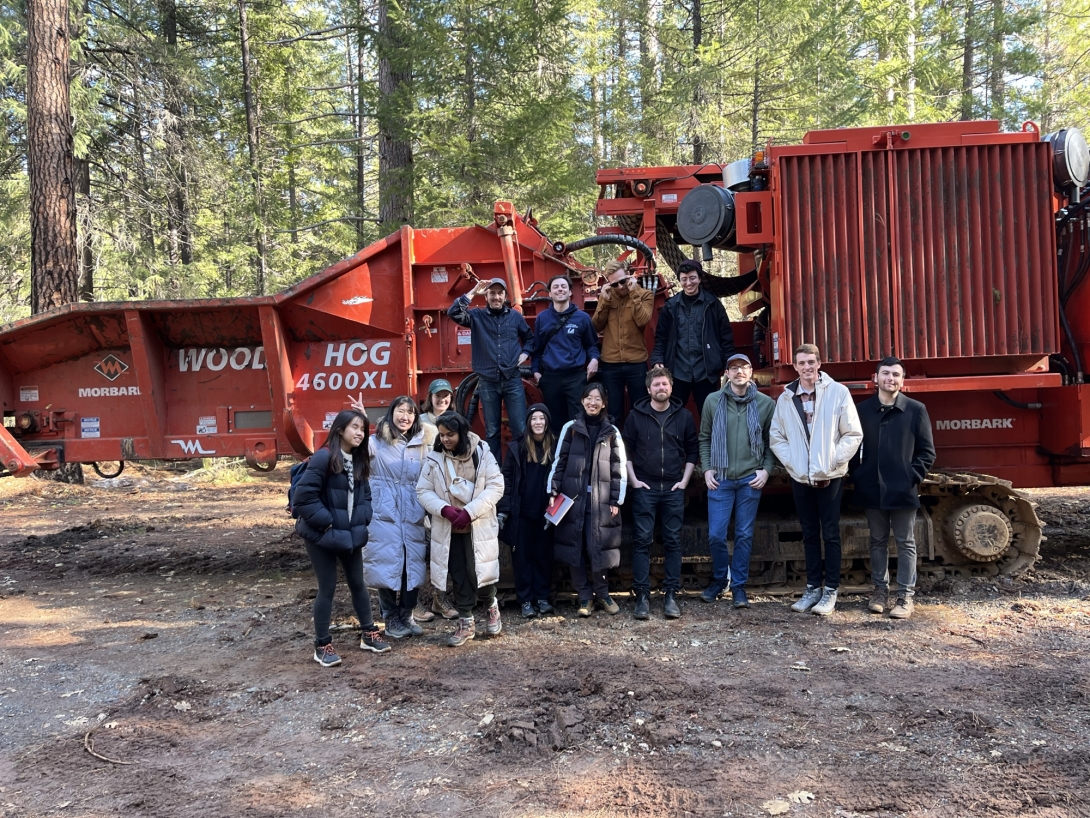 Group of young people in front of red heavy equipment