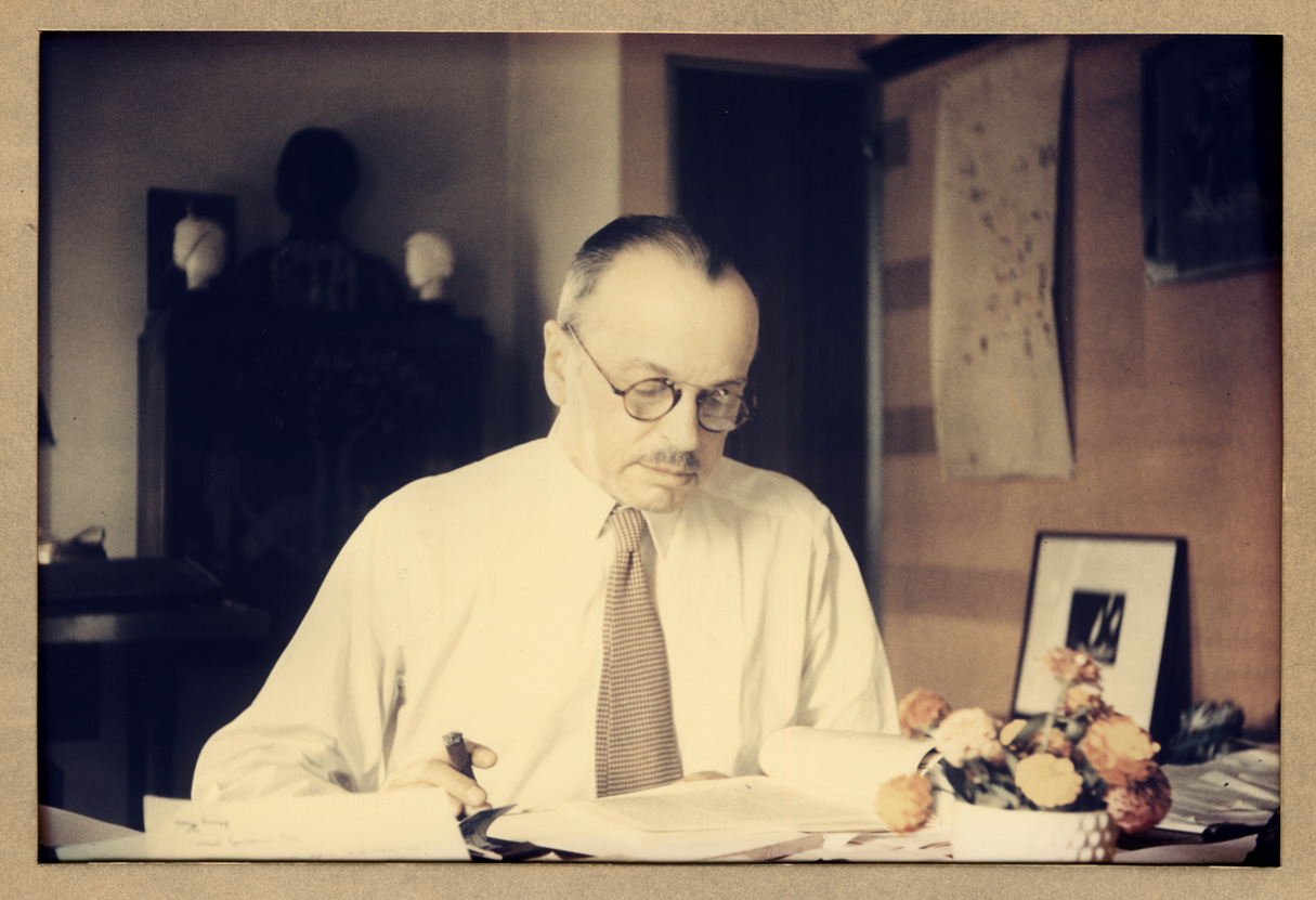 Color portrait of Paul Cret sitting at desk