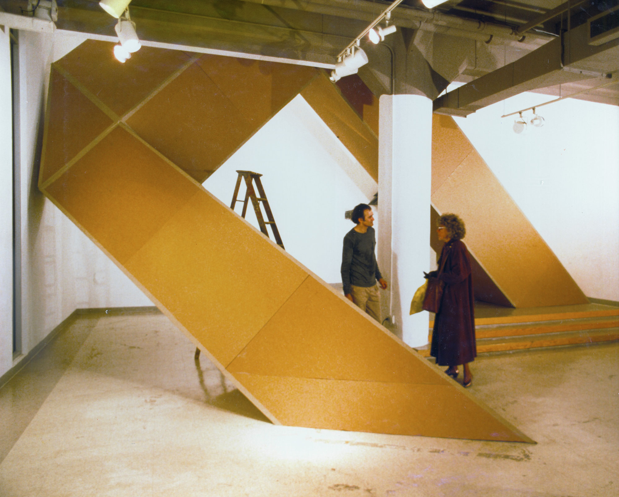 Robinson Fredenthaler with a large yellow metal schulpture in a gallery