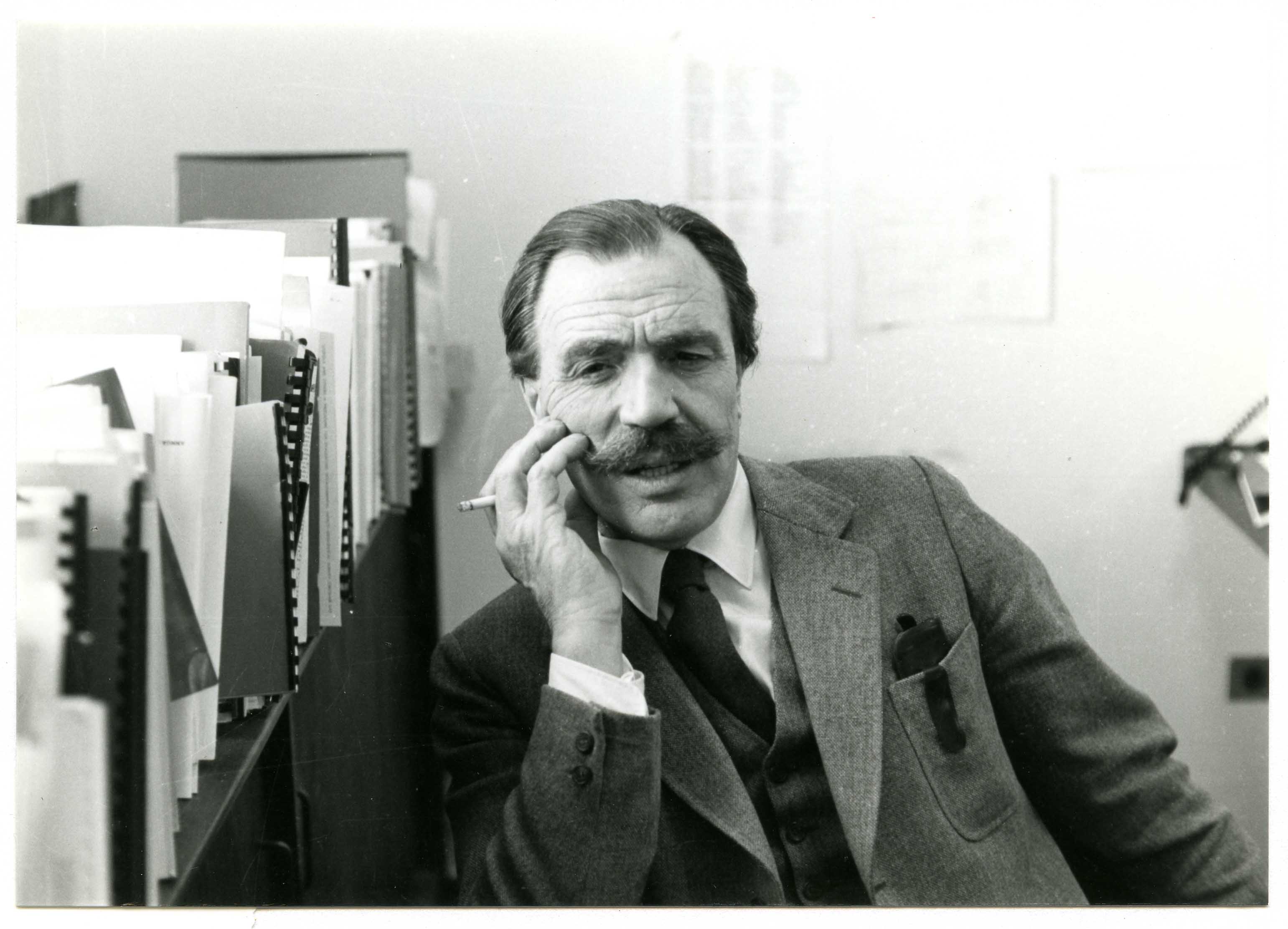 Black and white photo of man smoking in office