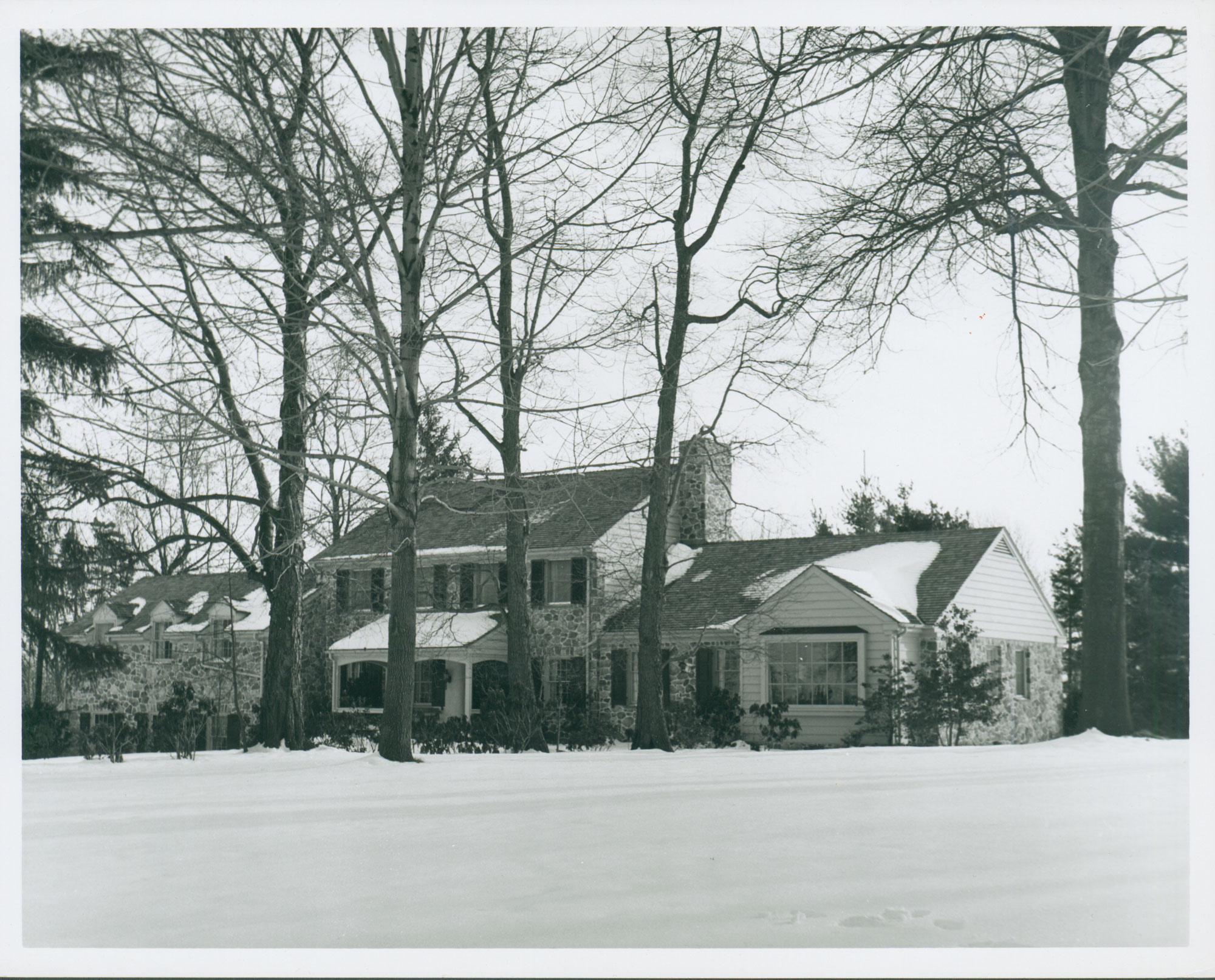black and white photo of colonial revival house in the snow