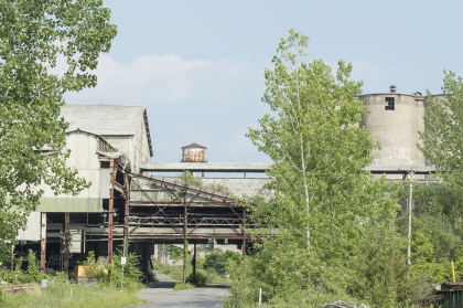 Old factory with trees growing around.