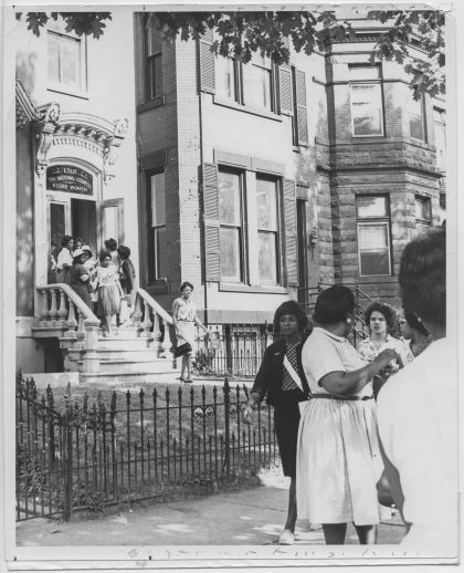 Black woman walking down steps of rowhouse