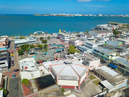 View of The Del Carmen Church from above in front of a plaza & the San Juan bay. 