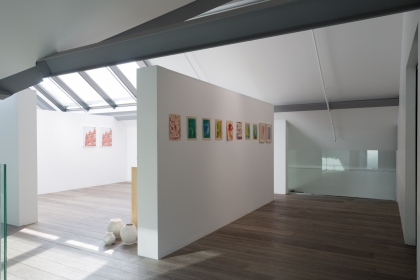 Gallery with many images up on the walls.