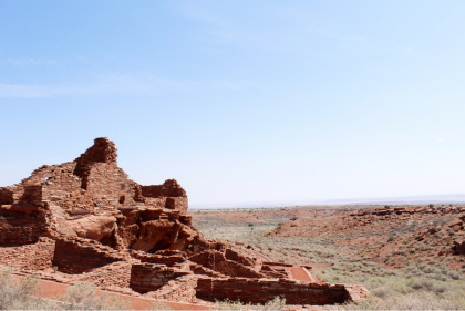 Brick-red structure/ruin overlooking desert landscape