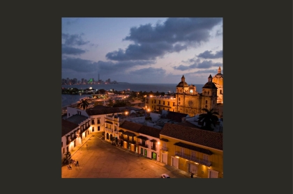 Cartagena historic fort lit up at night with modern city in background