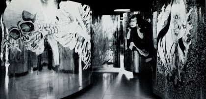 B&W photo of winding mural labyrinth featuring a collage of traditional Japanese paintings of samurai and folklore monsters