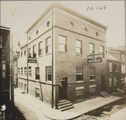 Black and white photo of a building with a sign: Public Baths and Wash House