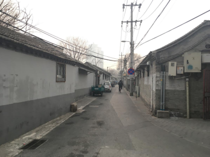 White and gray one-story buildings line a narrow alley way
