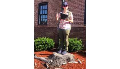 Haoyi's supervisor, Meg Frisbie, is using the arrow to record the location of the tree stump as part of the data collection proc