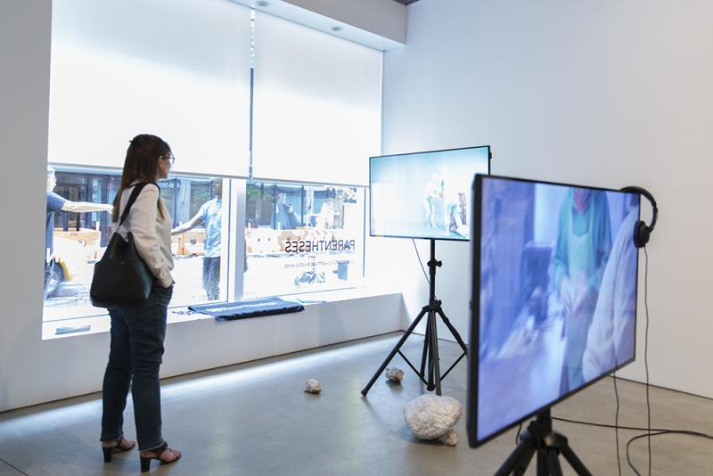 Video art pieces in gallery with student observer