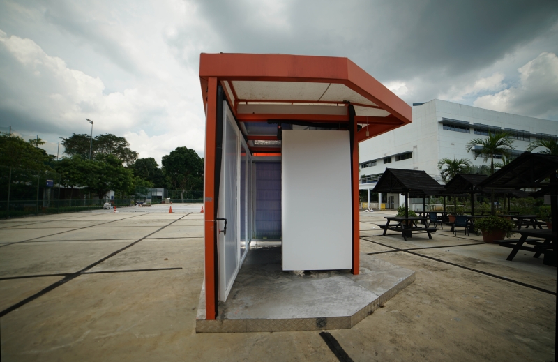 A radiant cooling pavilion with orange-painted steel frame and panelize walls in a site in Singapore