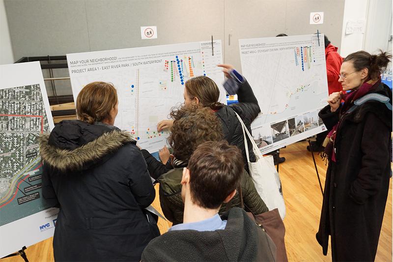 Students reading a poster board display.