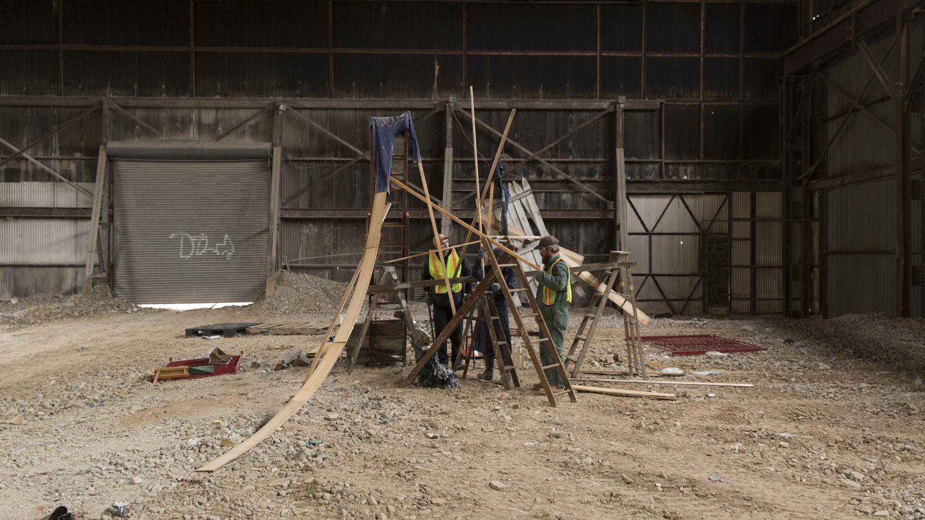 Large empty warehouse with two men working on an installation