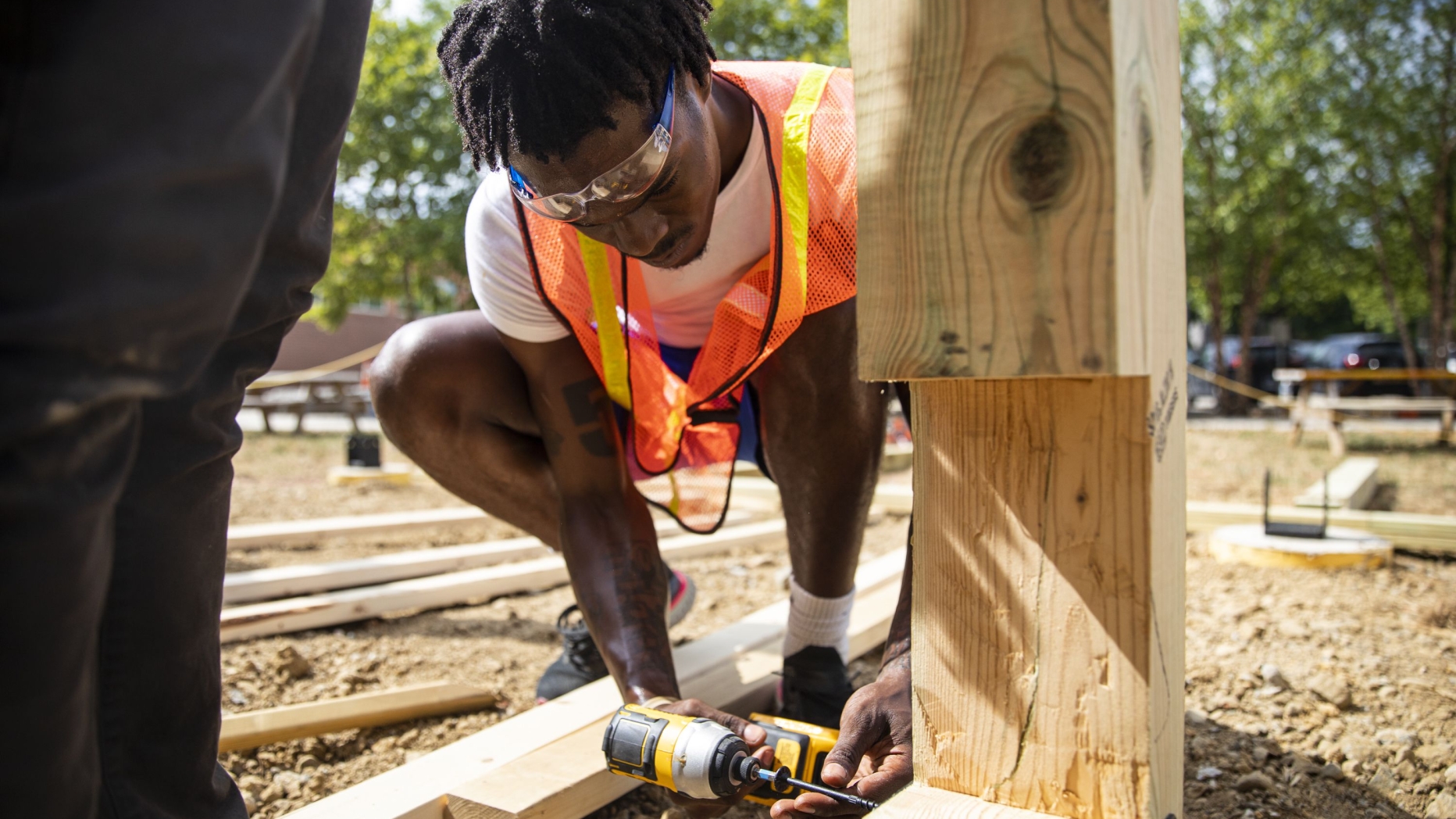 A person drills into a wooden structure