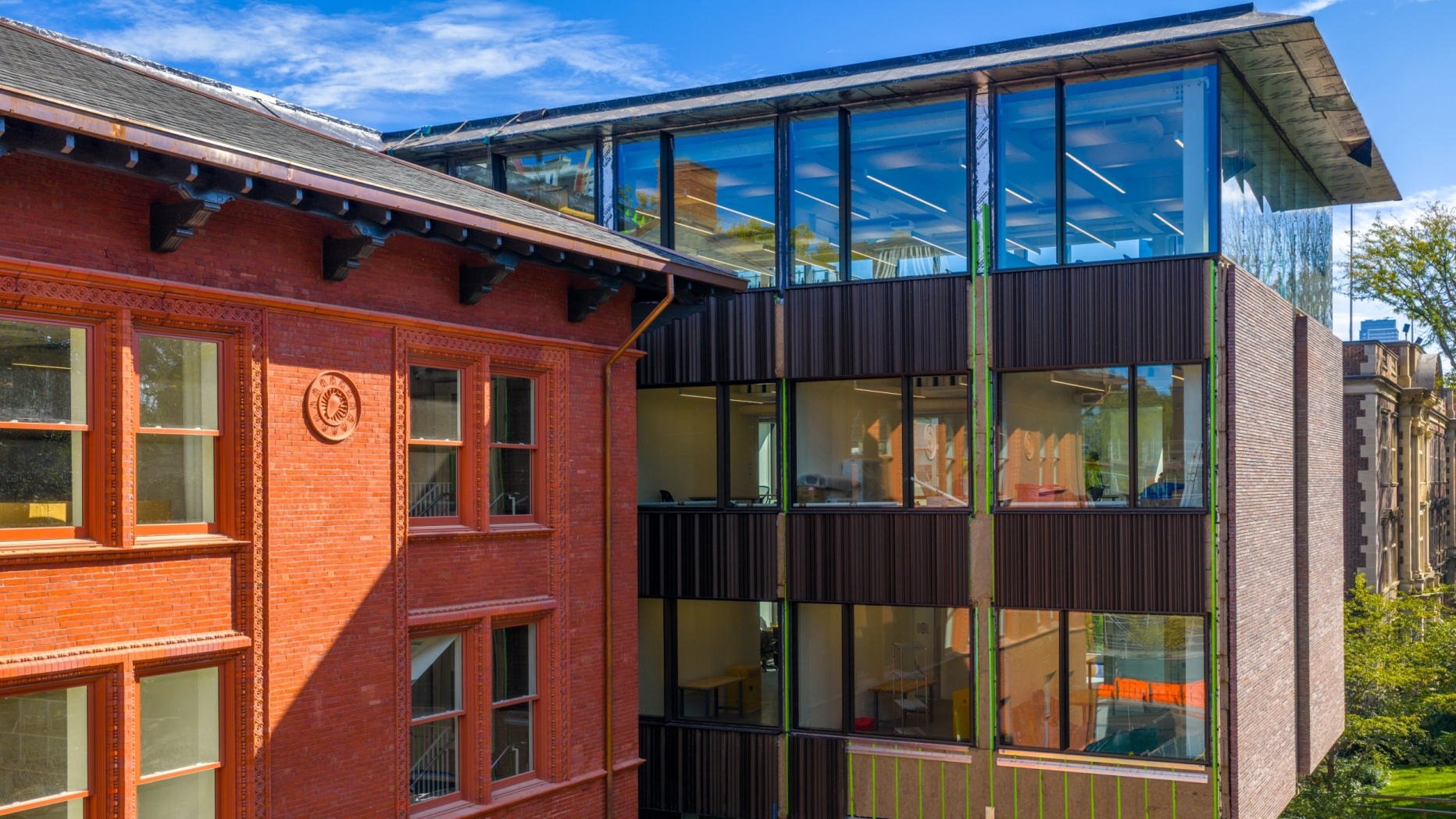 Brick building next to glass and brown brick addition