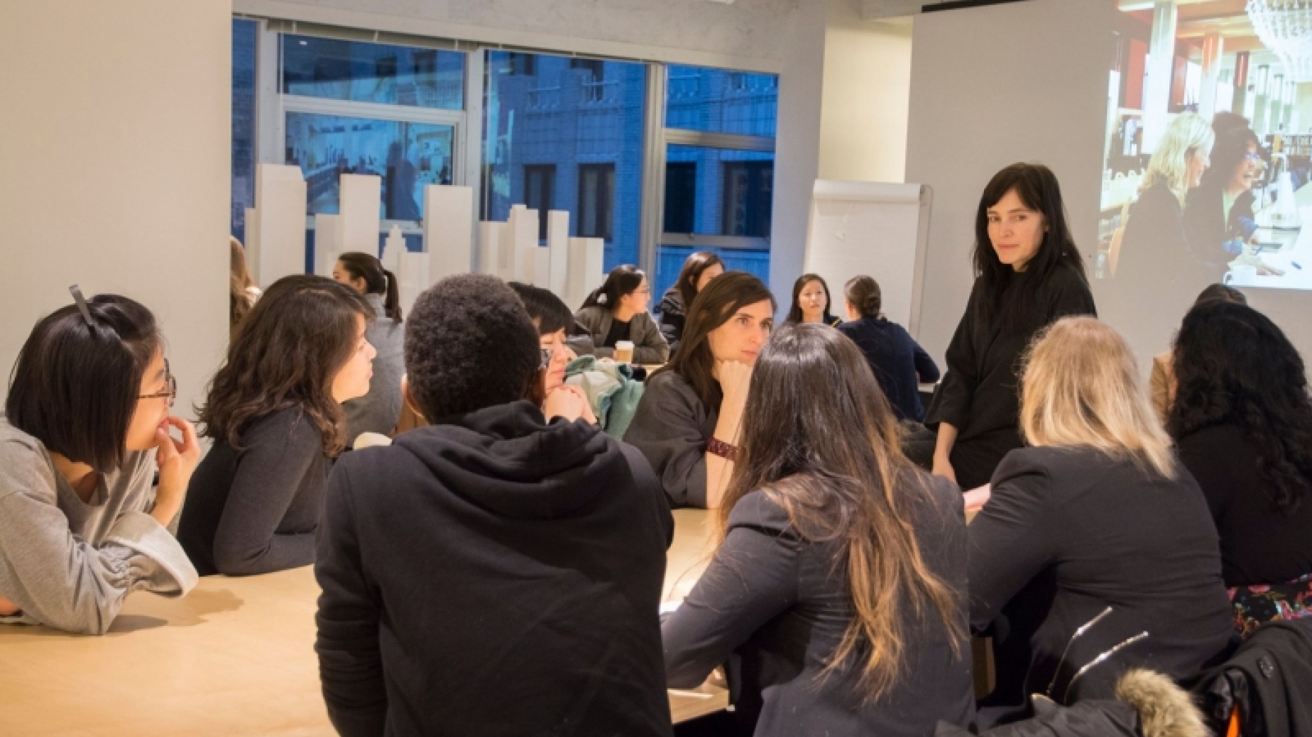 Group having discussion with one woman standing 