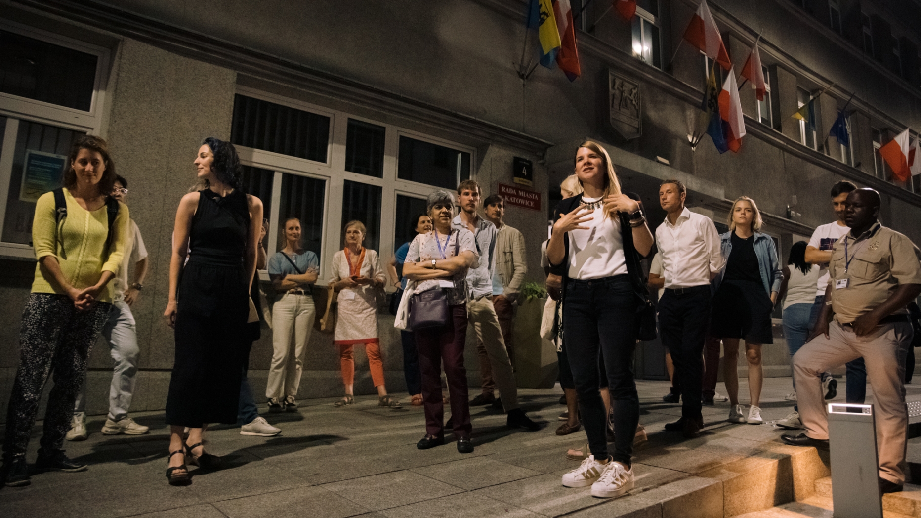 Crowd walking on street at night.