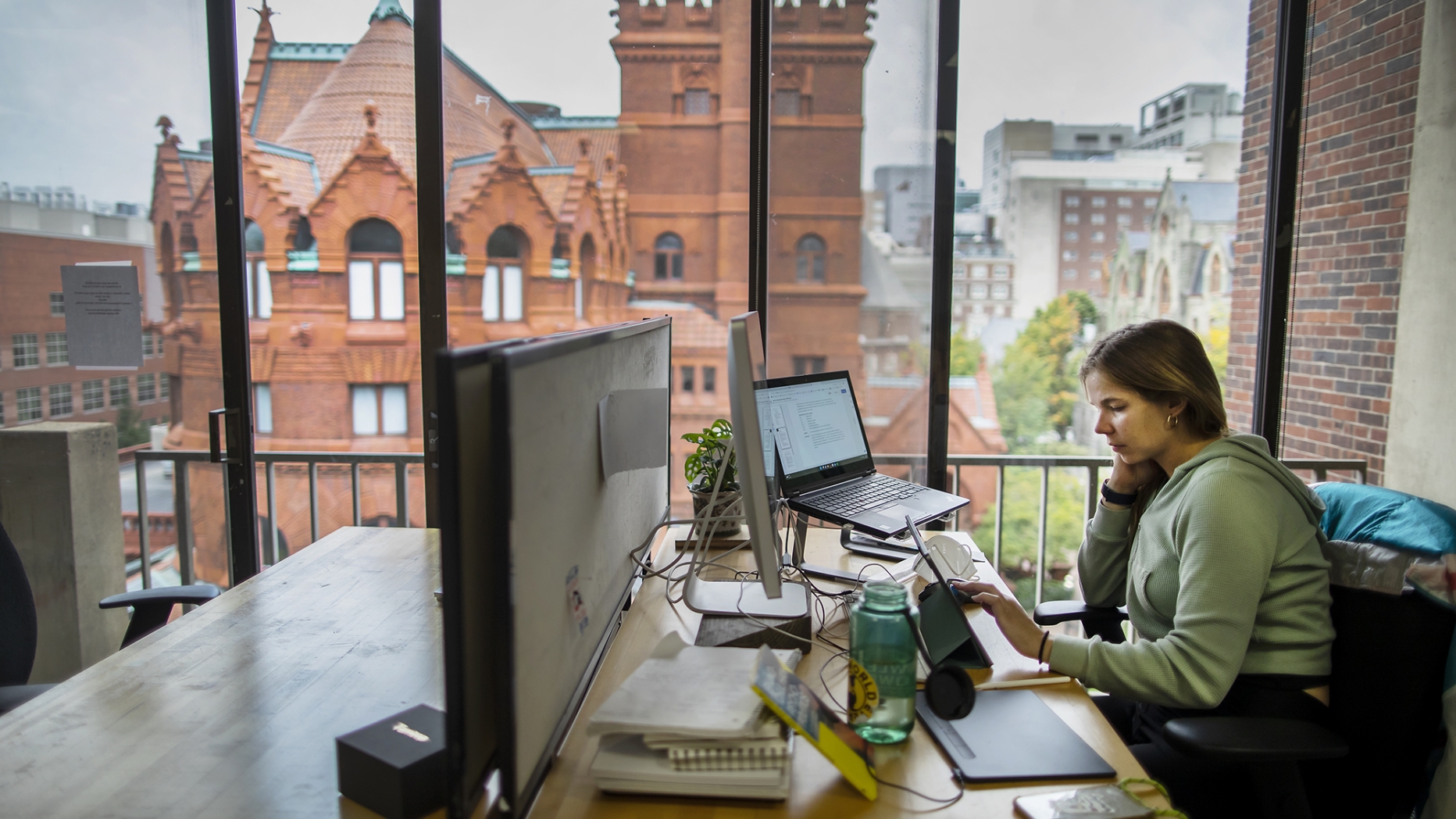 Student working at a desk next to a window