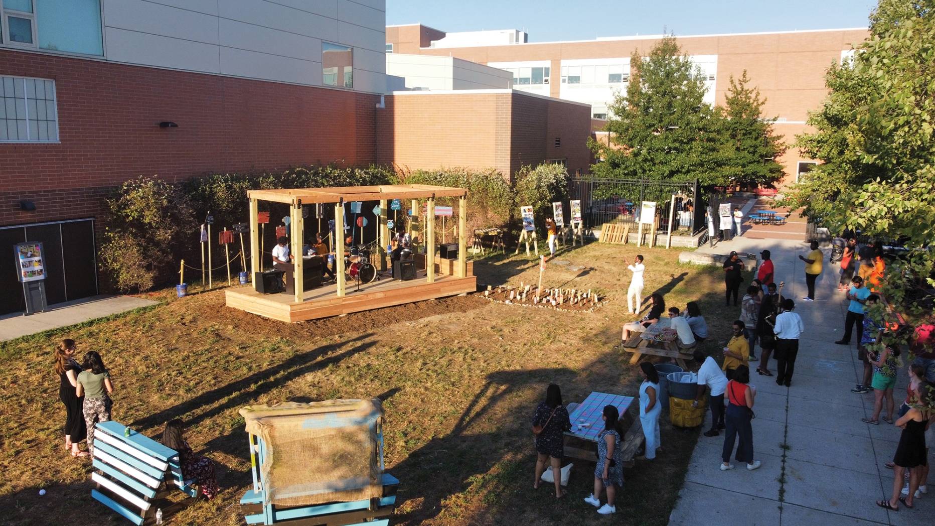 A view of the school yard with the wooden structure and a band playing on it