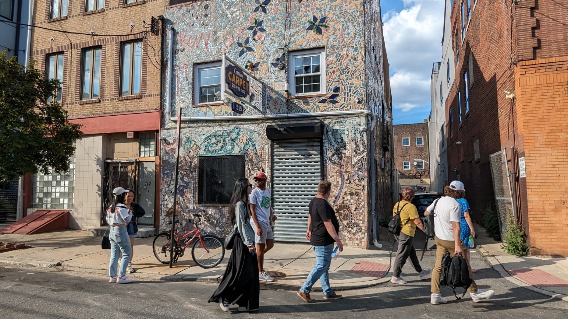 students walk in front of mosaicked rowhouse