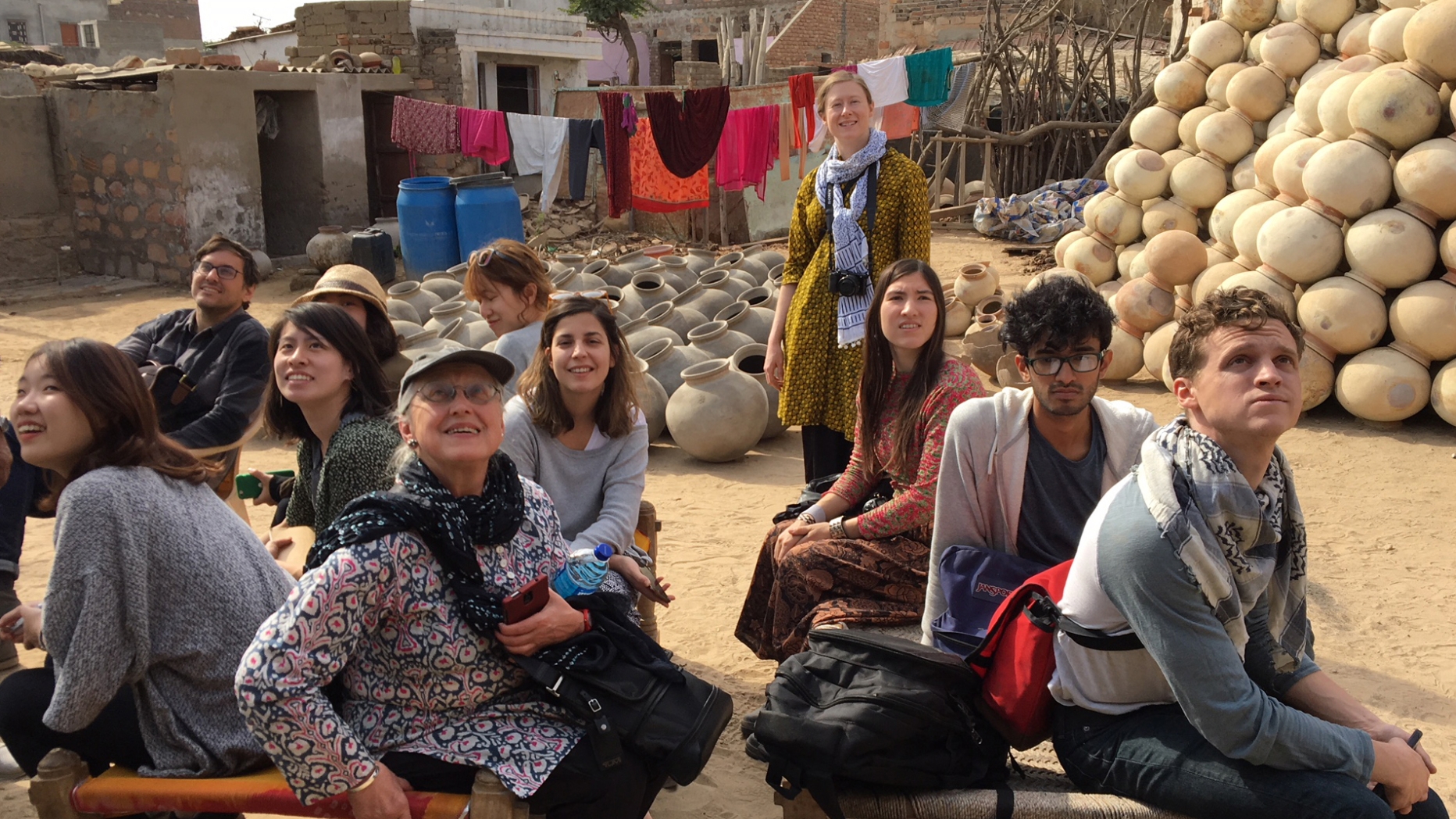 Penn students sitting with lots of pottery in the background.