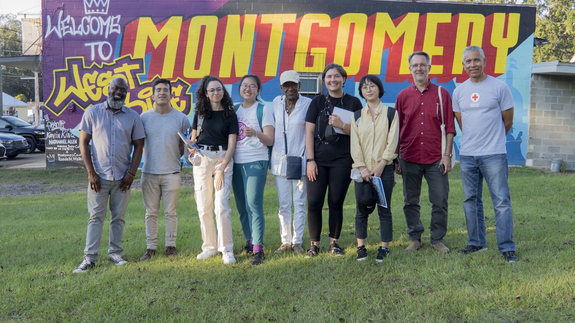 Group of people standing in front of colorful mural