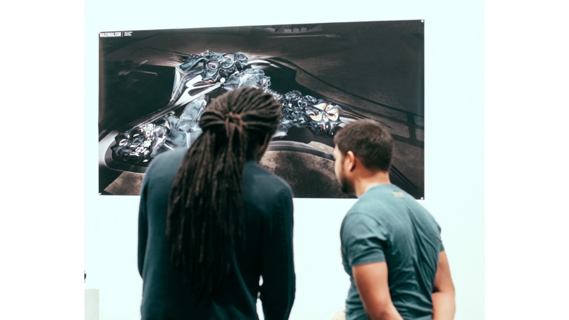 Two students examining art piece