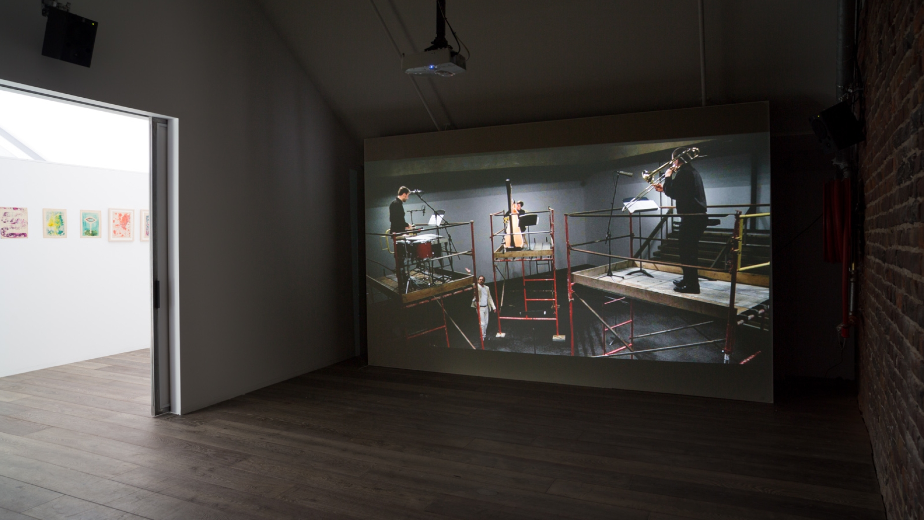 Gallery with image projected on to a wall in a dark room