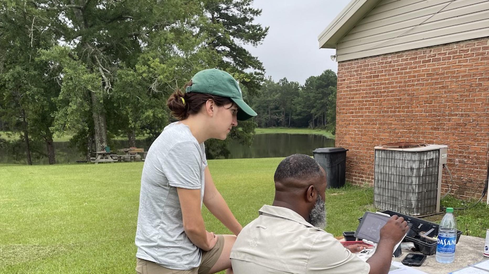 Man and woman working together outside with a drone on a table