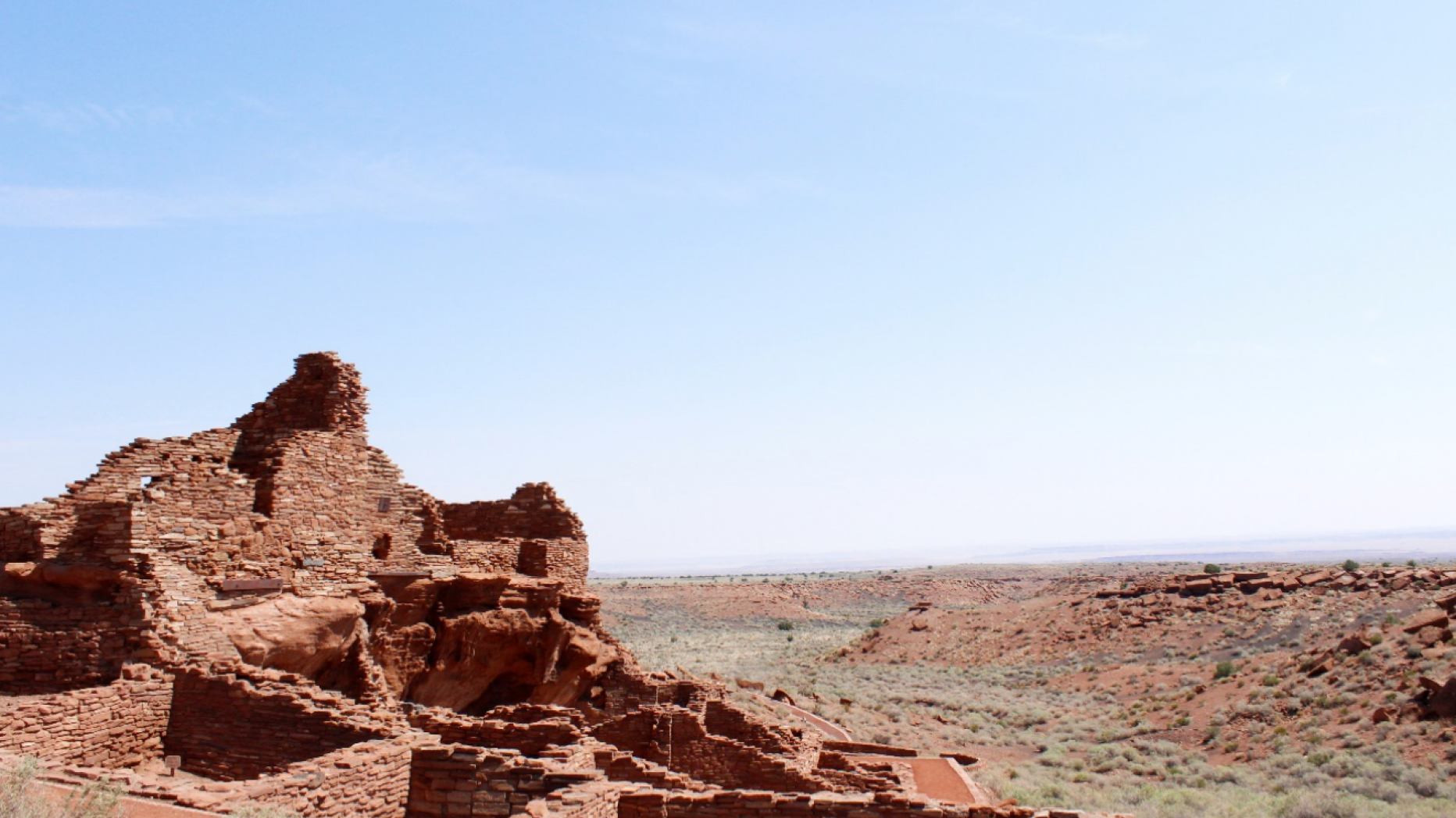 Brick-red structure/ruin overlooking desert landscape