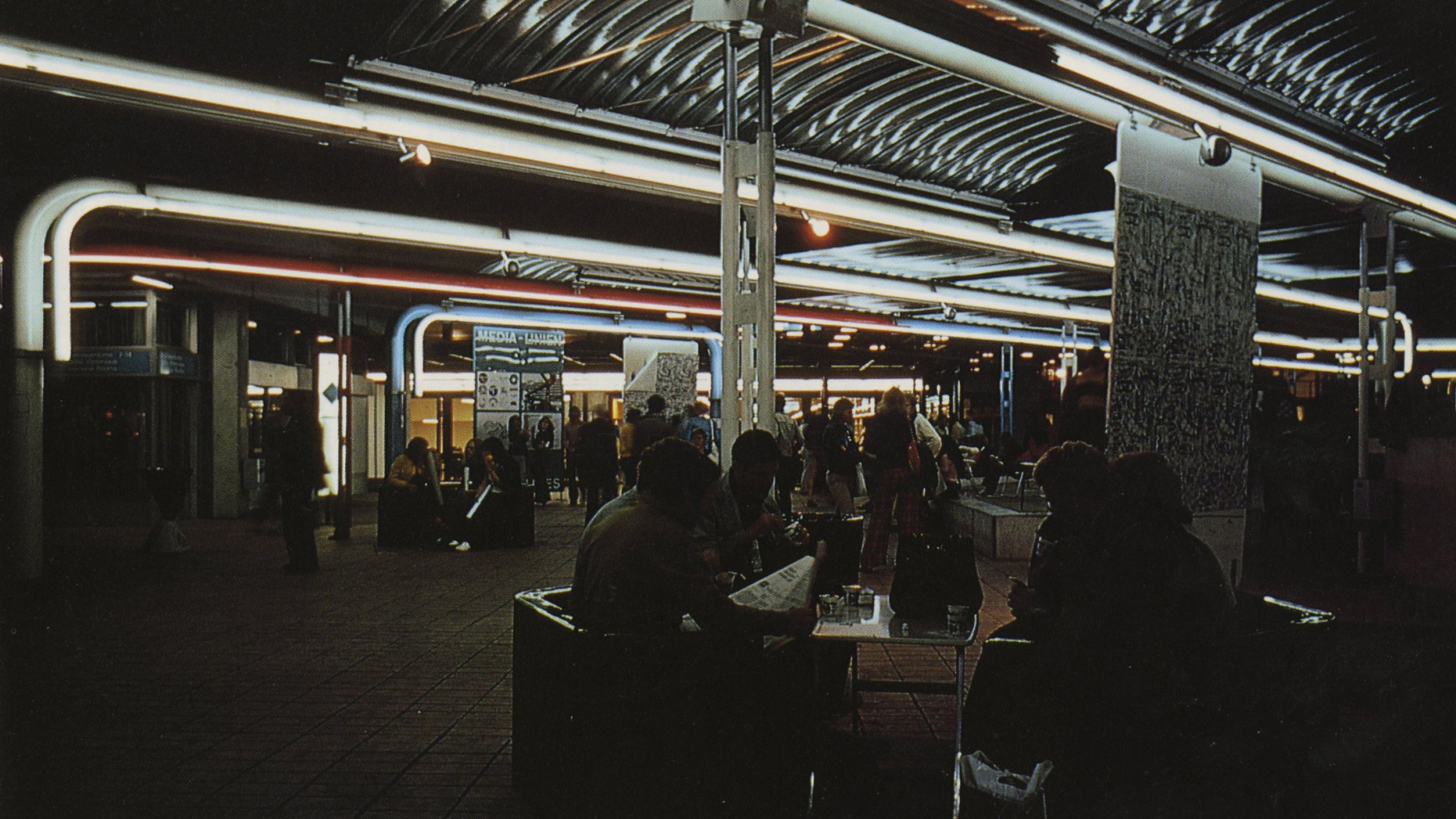 Lounge space with soft neon lighting and lots of people hanging out