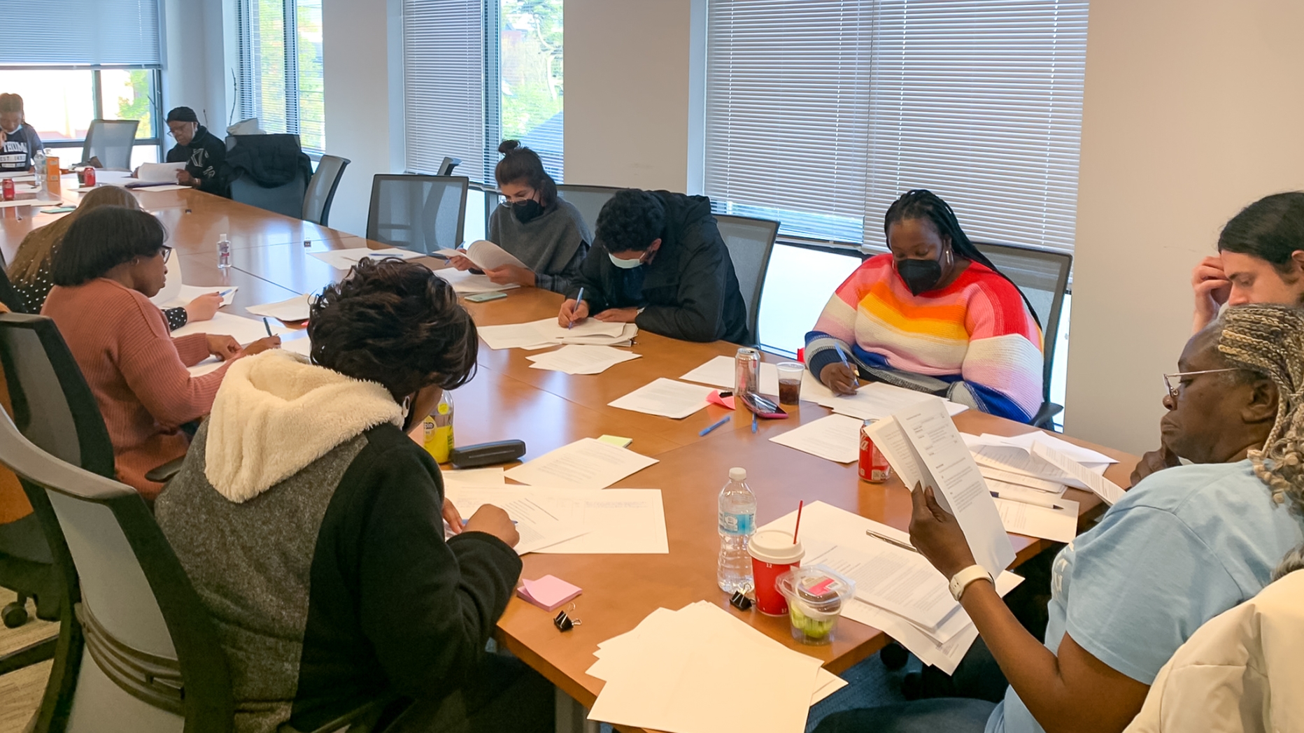 A group of people sitting around a conference table reading reports