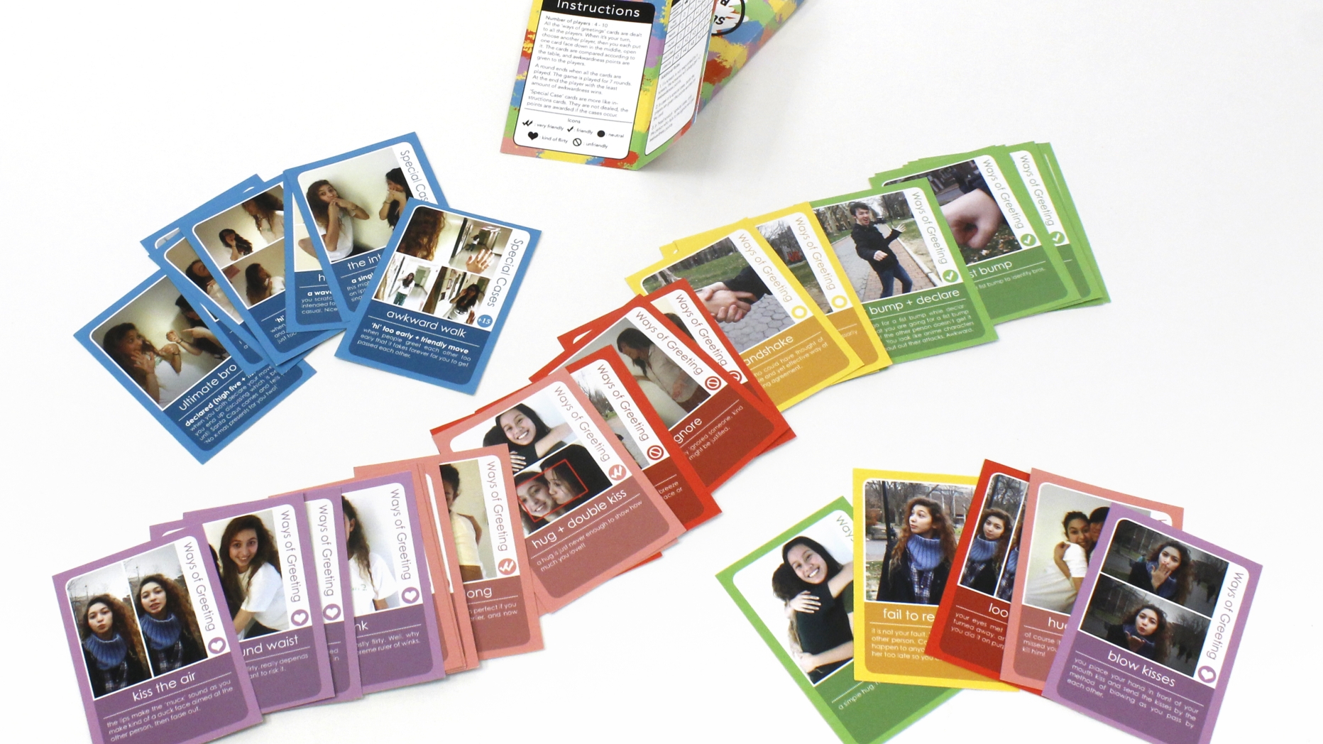 A card game. There are several different colors types and each card has a picture of a person doing something and text underneath.