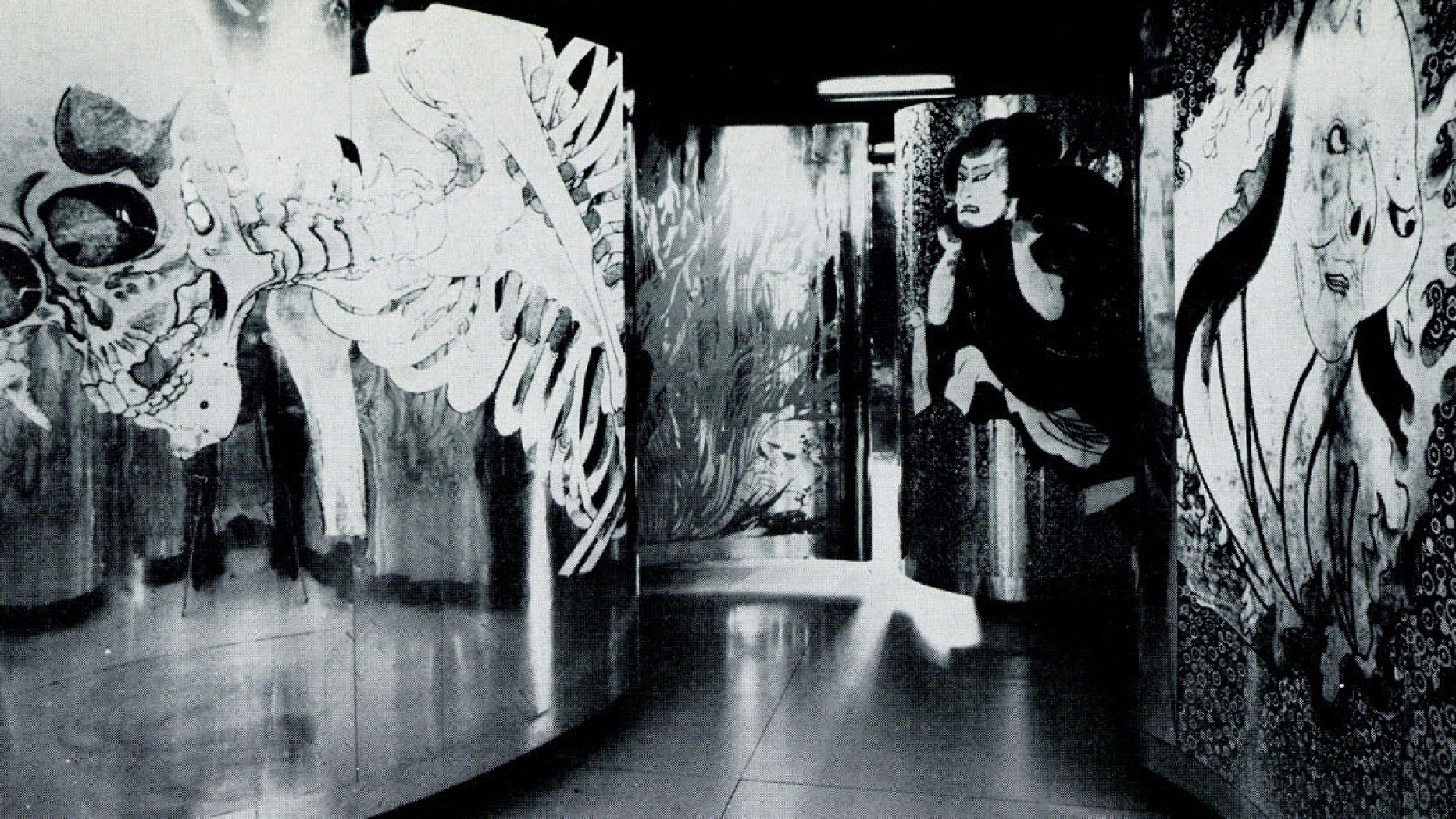 B&W photo of winding mural labyrinth featuring a collage of traditional Japanese paintings of samurai and folklore monsters