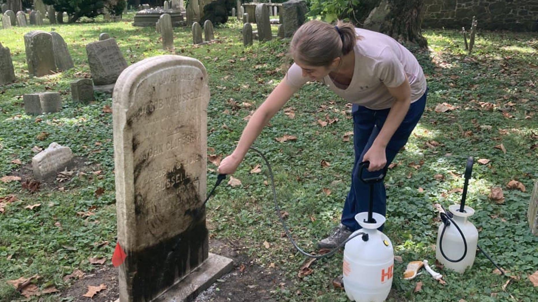 Cleaning a grave marker in a cemetery
