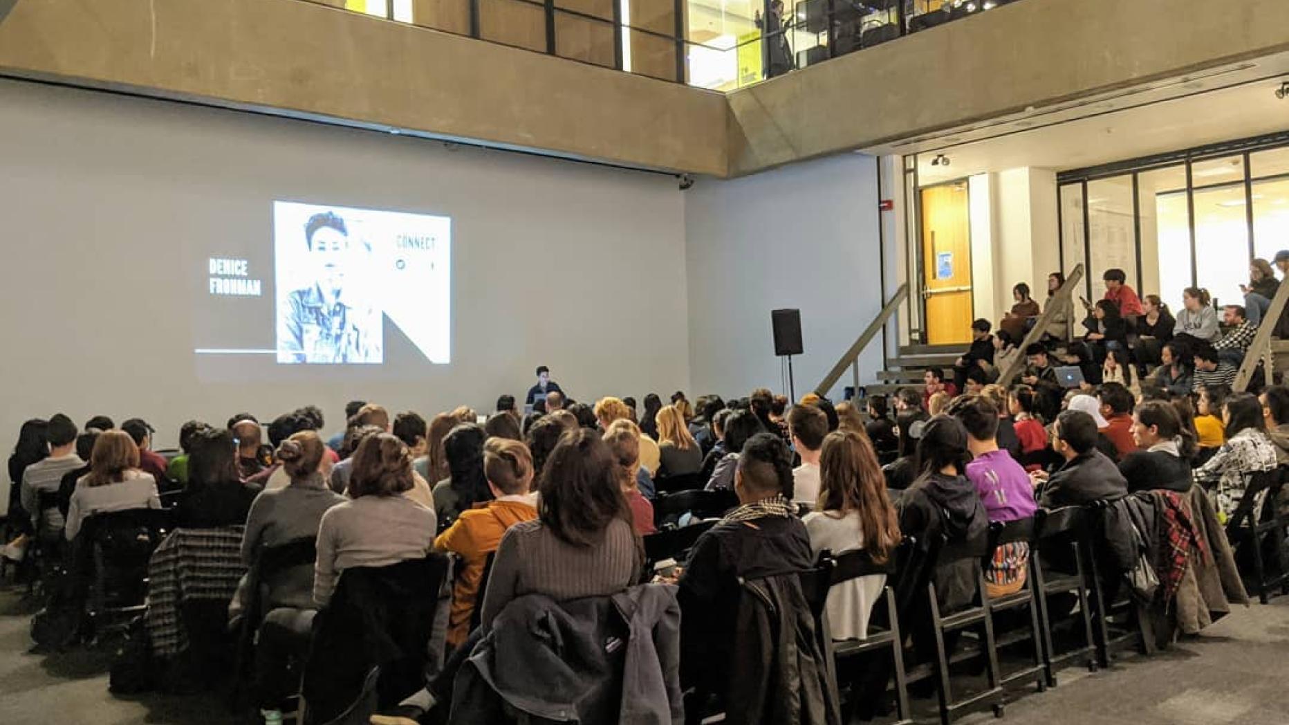 Large group of students viewing a video on the wall