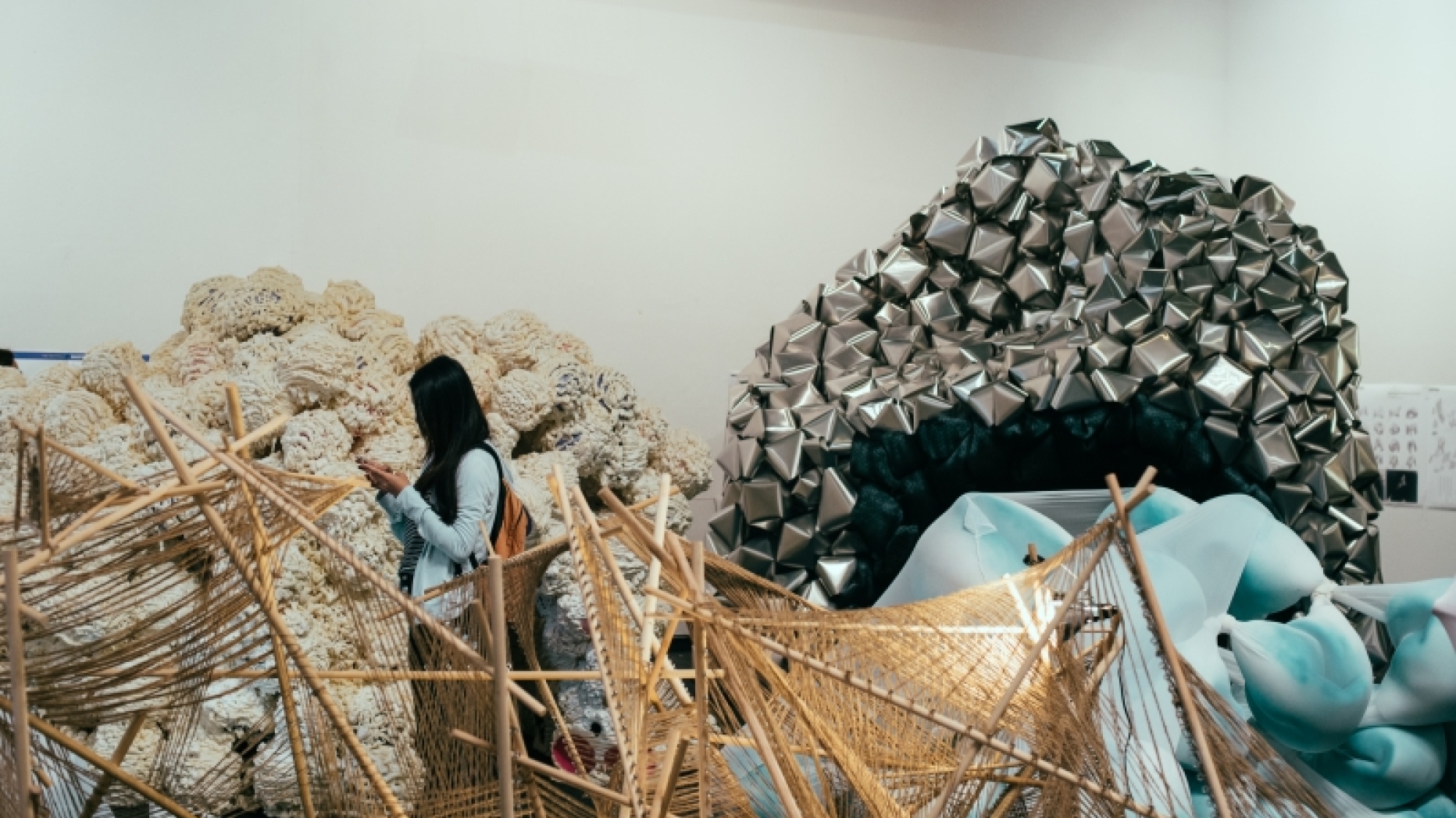 Collection of large abstract sculptures and one woman examining them.