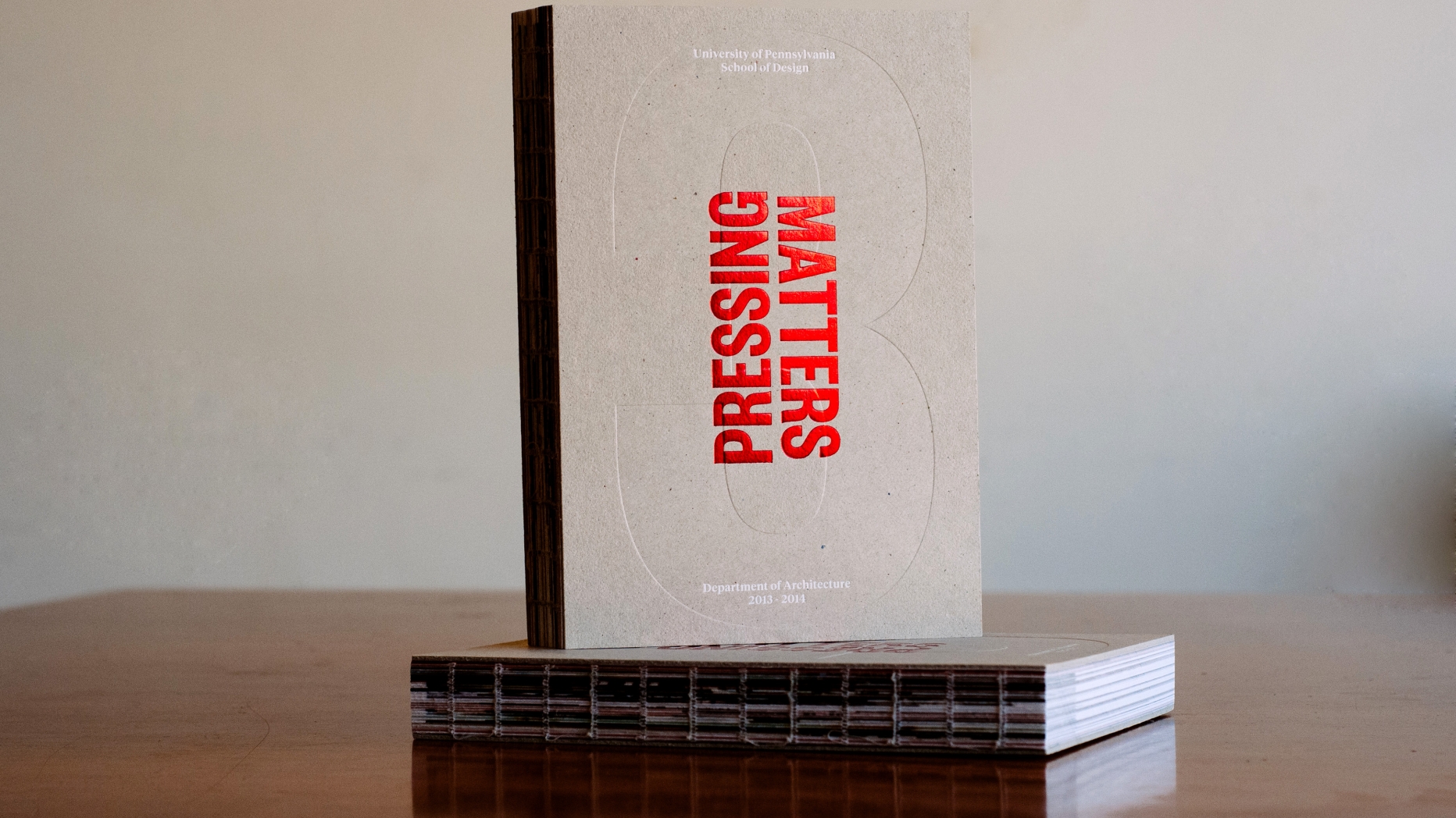 Two copies of publication 'Pressing Matters 3"on wooden table.