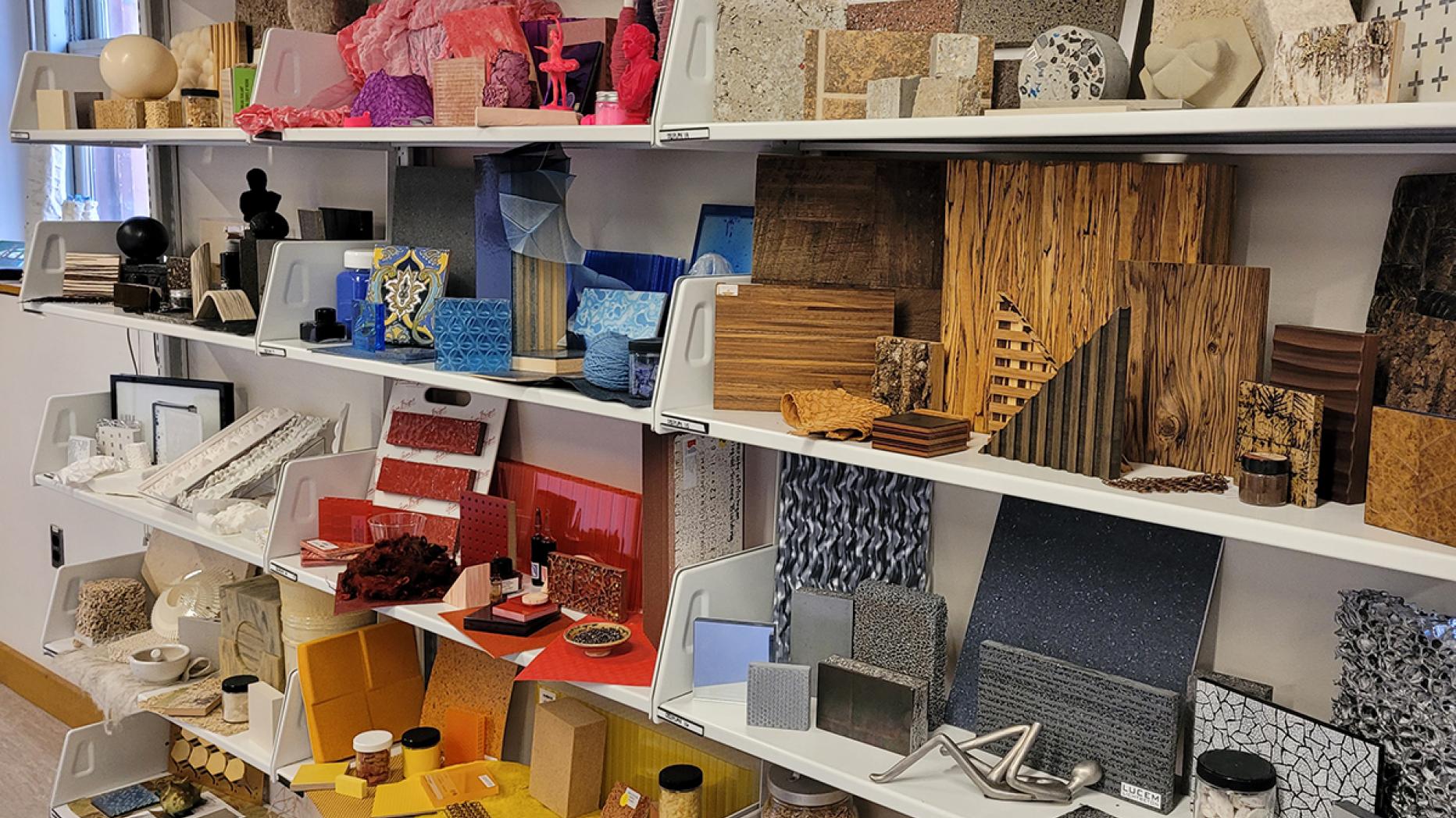 Shelves full of wood and stone tiles, paint jars, and acrylic sheets in a rainbow of colors